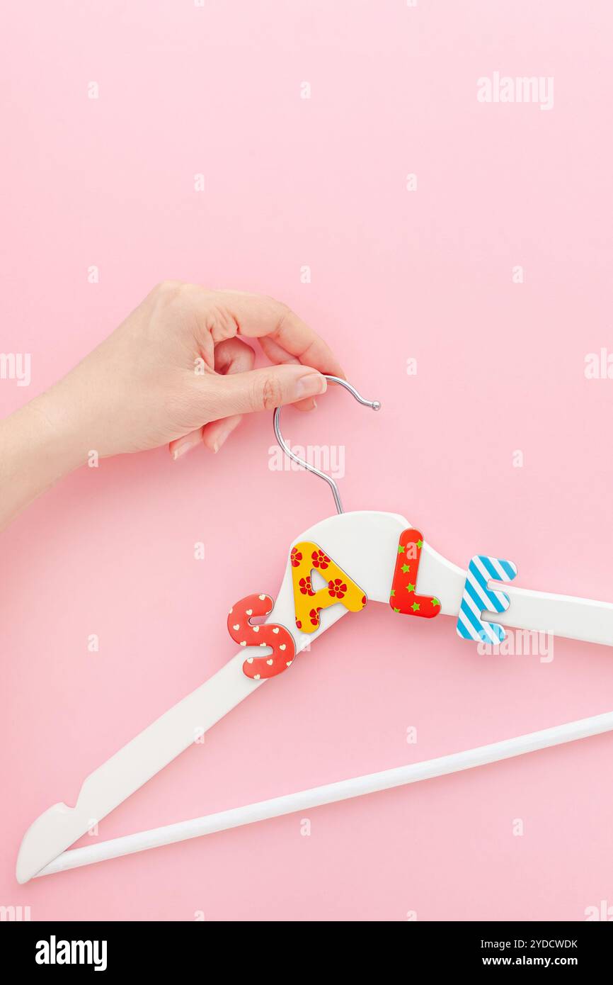 Appendiabiti bianchi con testo di vendita su sfondo rosa Foto Stock