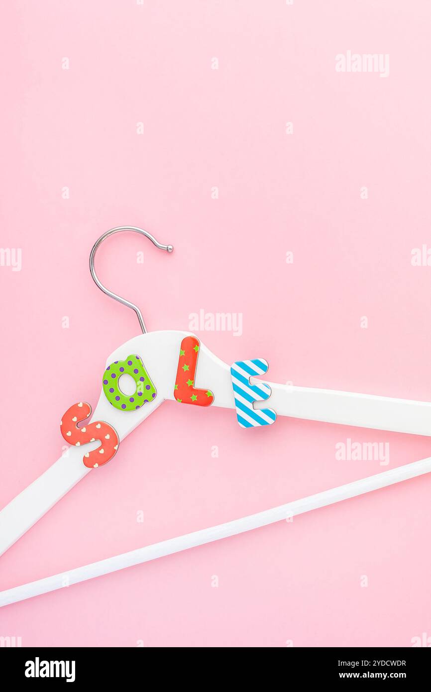 Appendiabiti bianchi con testo di vendita su sfondo rosa Foto Stock