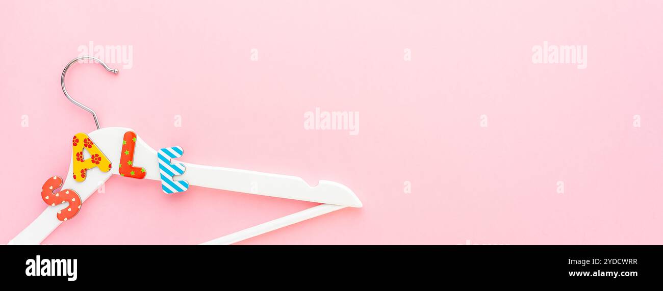 Appendiabiti bianchi con testo di vendita su sfondo rosa Foto Stock