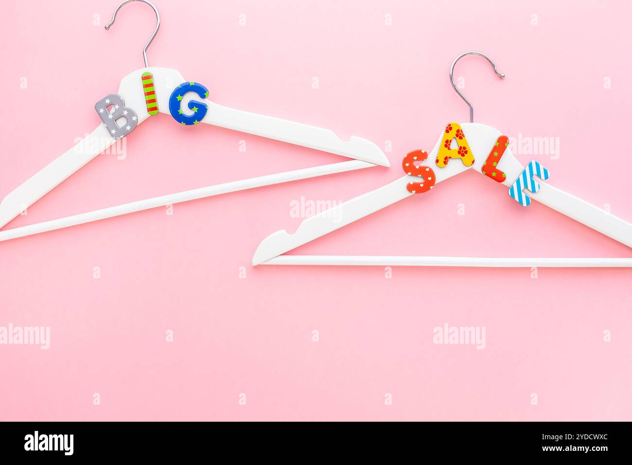 Appendiabiti bianchi con testo di vendita su sfondo rosa Foto Stock