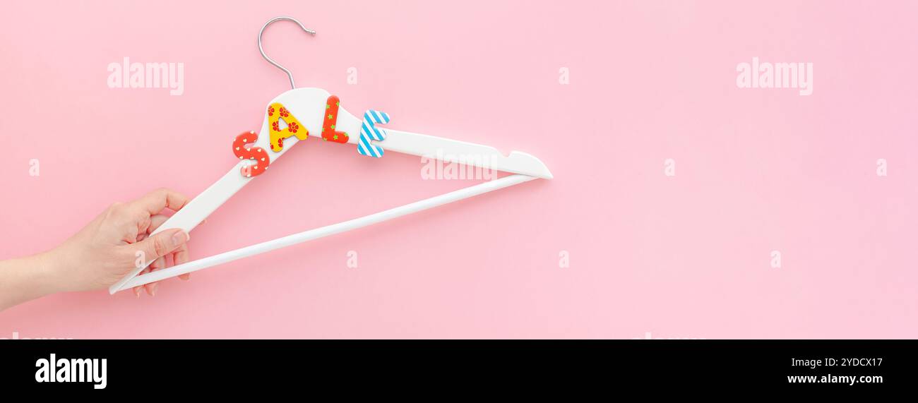 Appendiabiti bianchi con testo di vendita su sfondo rosa Foto Stock