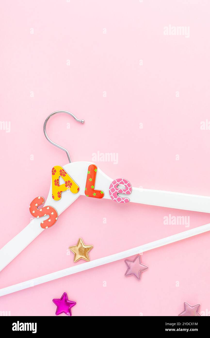 Appendiabiti bianchi con testo di vendita su sfondo rosa Foto Stock