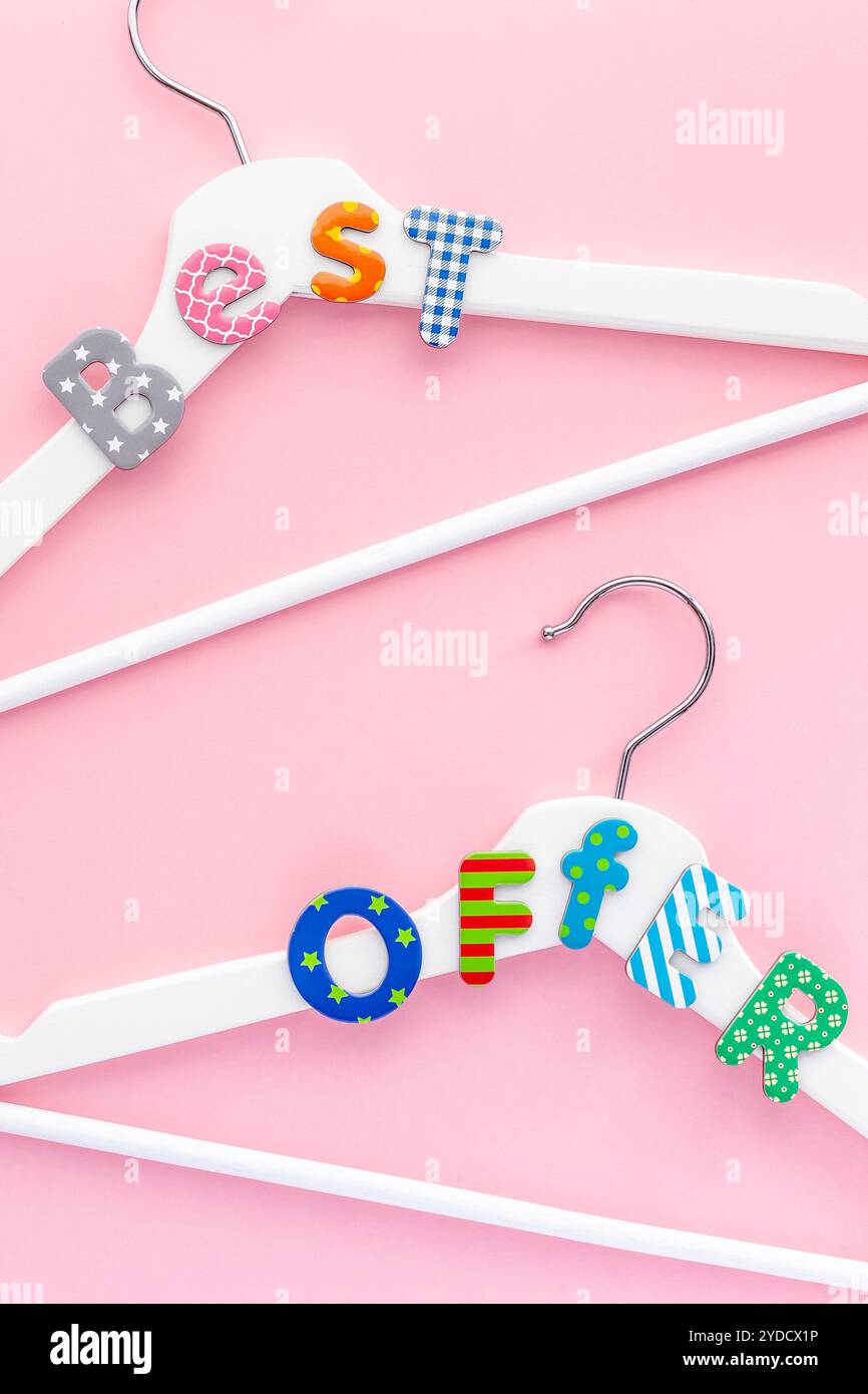 Appendiabiti bianchi con testo di vendita su sfondo rosa Foto Stock