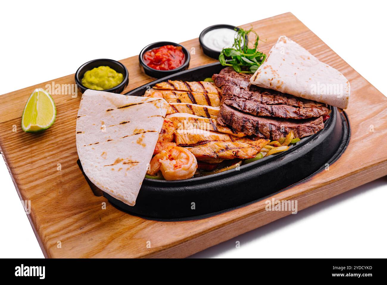 Fajitas di manzo e gamberi su un piatto di ghisa sfrigolante Foto Stock
