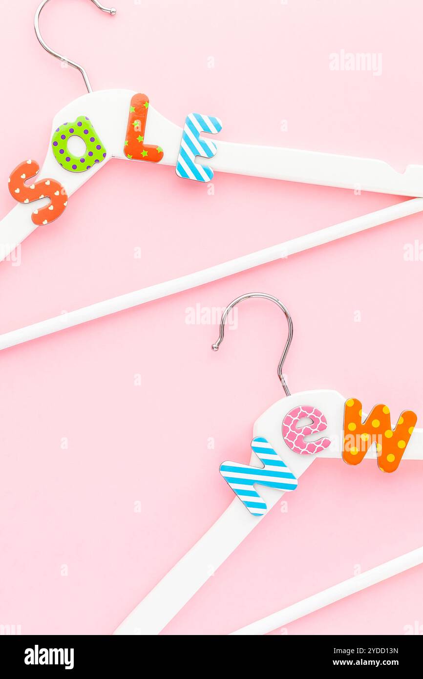 Appendiabiti bianchi con testo di vendita su sfondo rosa Foto Stock