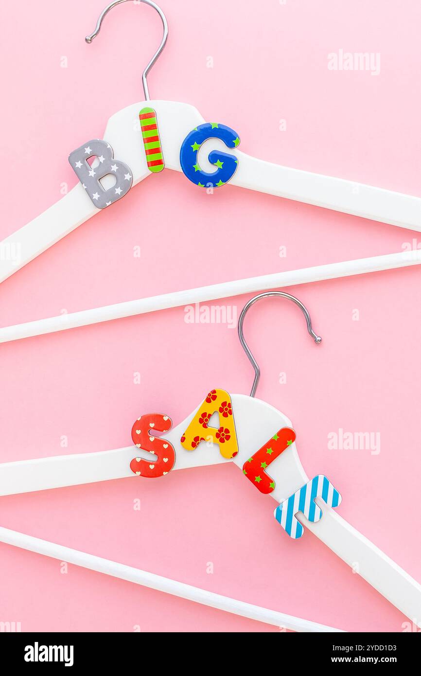 Appendiabiti bianchi con testo di vendita su sfondo rosa Foto Stock