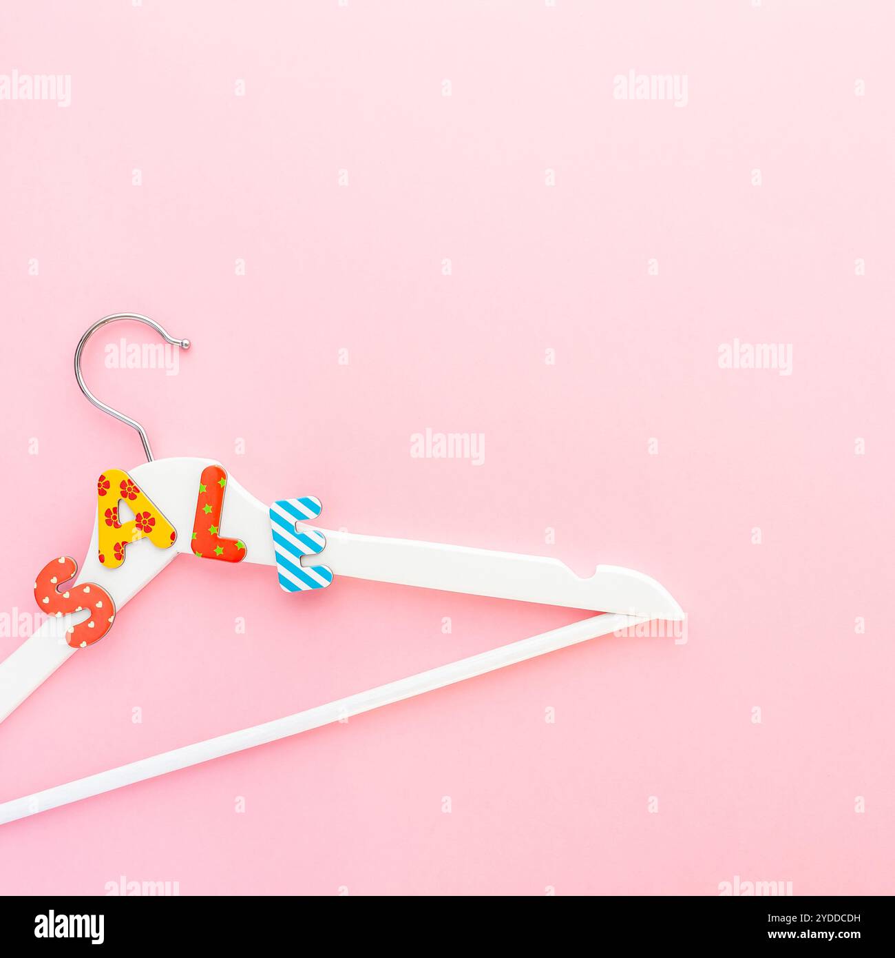 Appendiabiti bianchi con testo di vendita su sfondo rosa Foto Stock