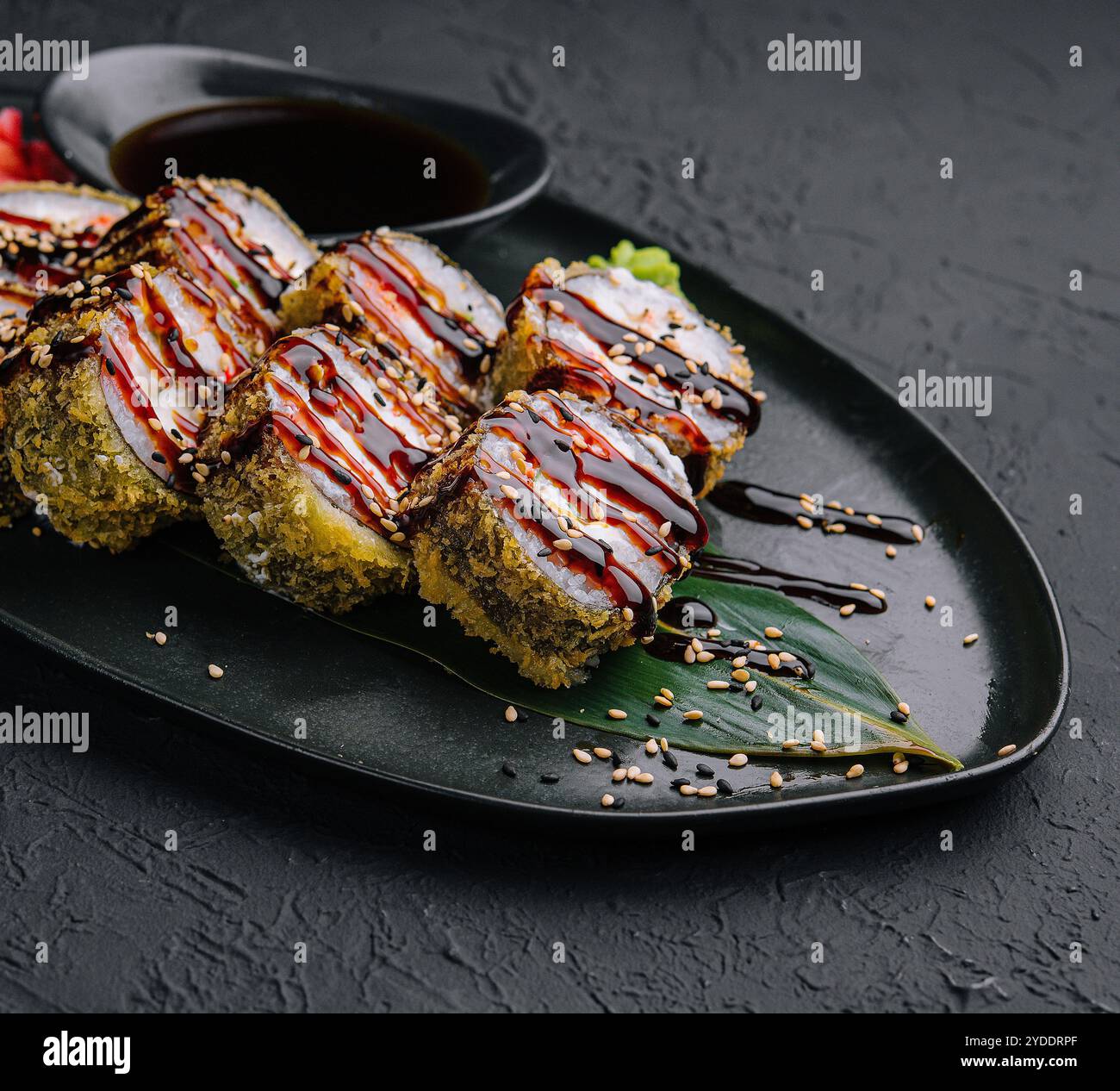 Involtini fritti tempura su sfondo nero Foto Stock