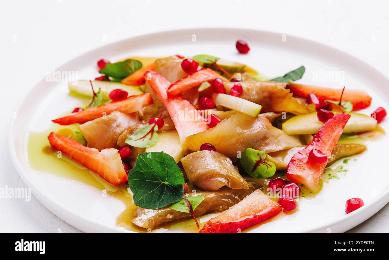 Pesce con fragole, pere e melograni in salsa Foto Stock