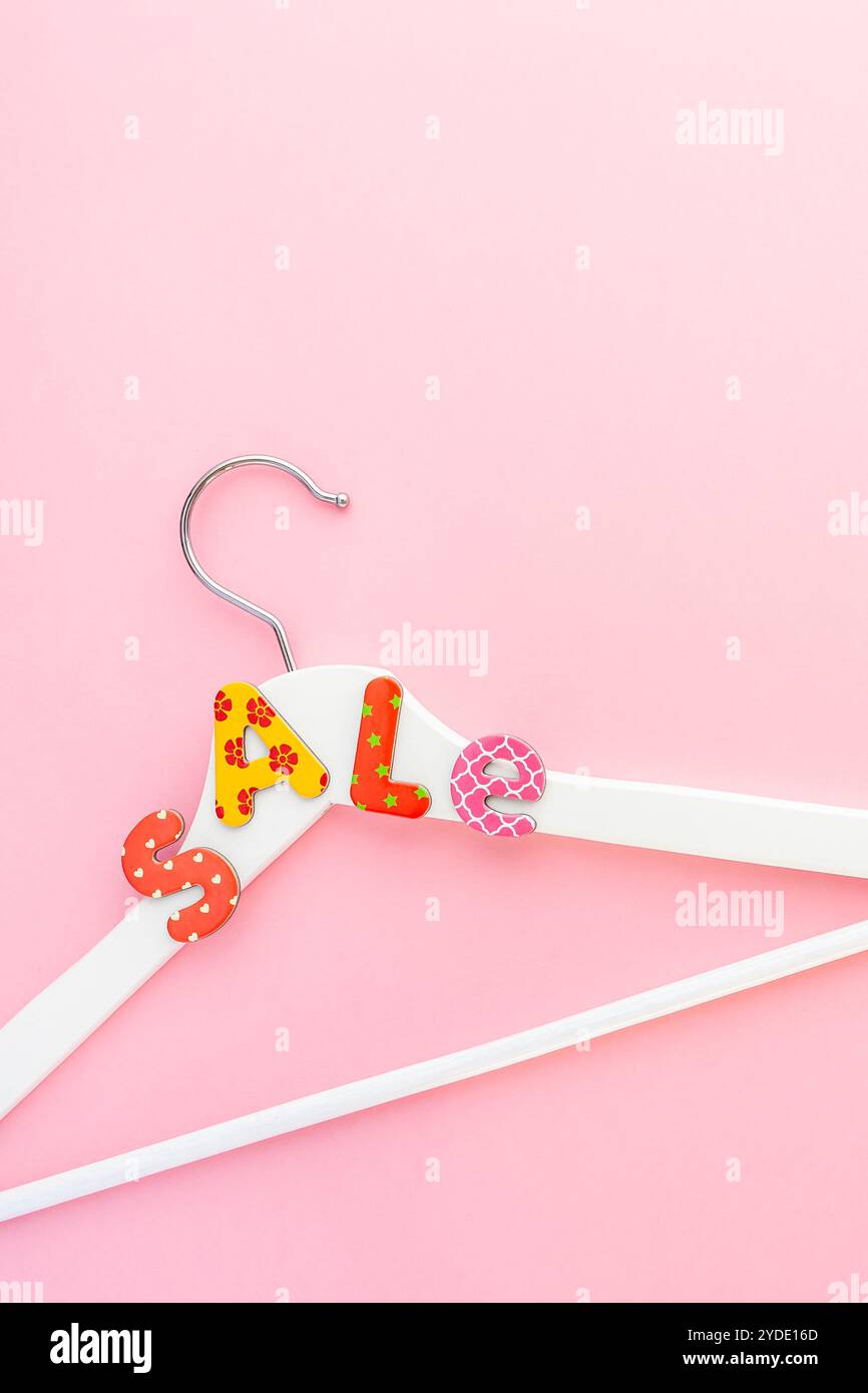 Appendiabiti bianchi con testo di vendita su sfondo rosa Foto Stock