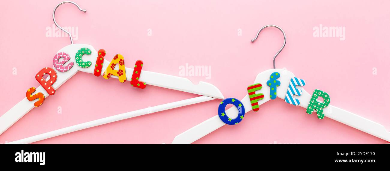 Appendiabiti bianchi con testo di vendita su sfondo rosa Foto Stock