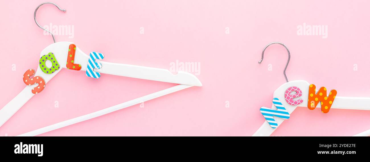 Appendiabiti bianchi con testo di vendita su sfondo rosa Foto Stock