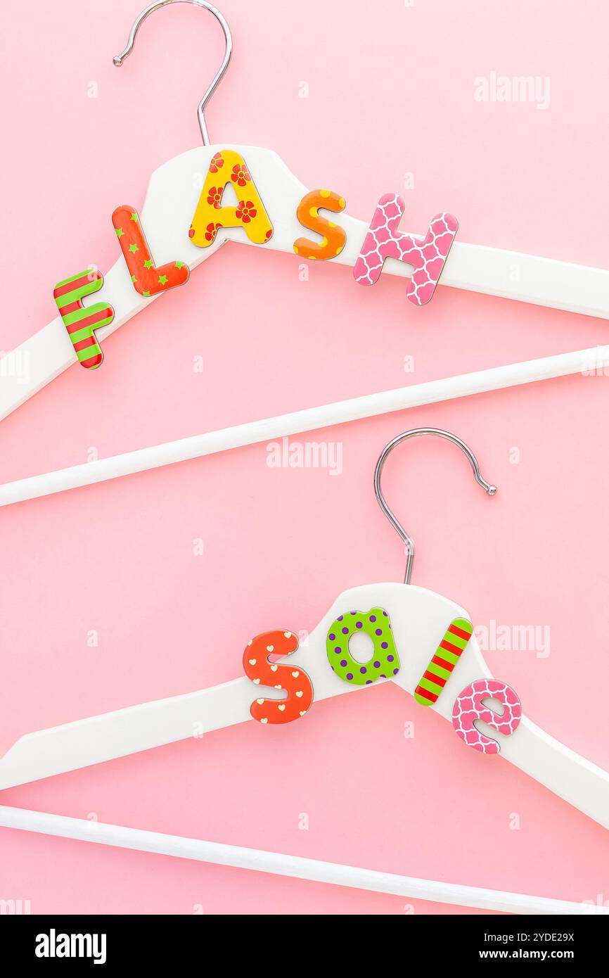 Appendiabiti bianchi con testo di vendita su sfondo rosa Foto Stock
