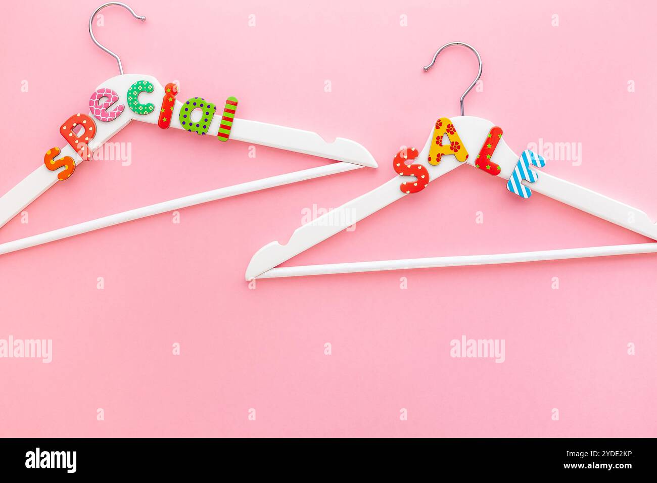 Appendiabiti bianchi con testo di vendita su sfondo rosa Foto Stock