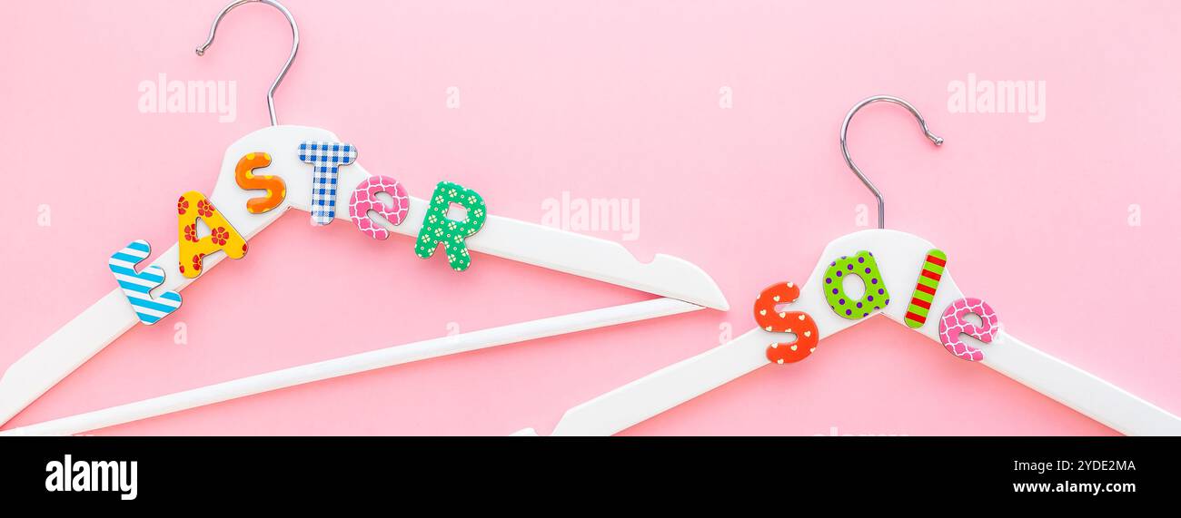 Appendiabiti bianchi con testo di vendita su sfondo rosa Foto Stock