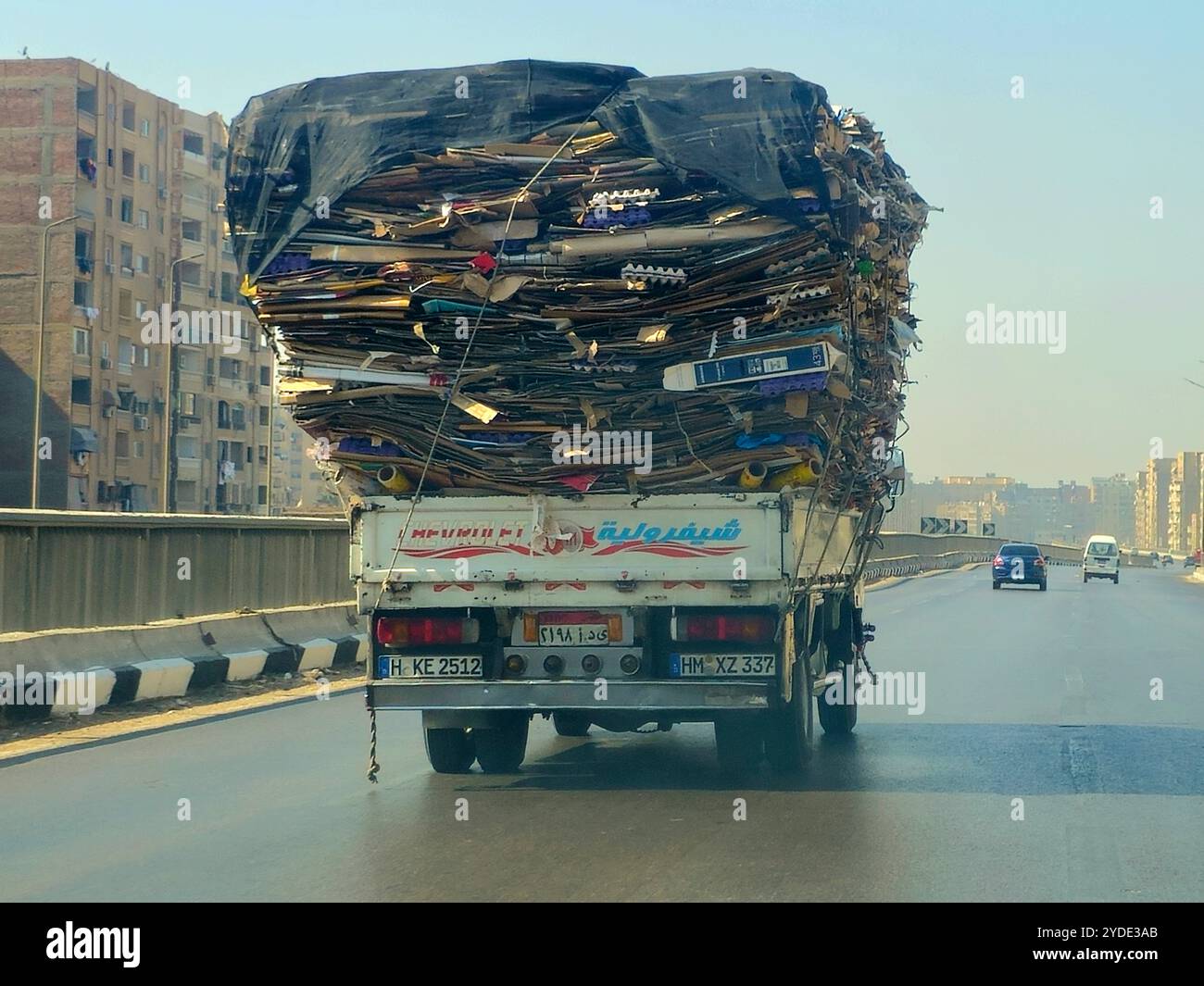 Giza, Egitto, 6 ottobre 2024: Un camion di trasporto pieno di rottami di carta di scarto di cartone marrone trasportati per il riciclaggio dopo essere stati raccolti, un camion ve Foto Stock