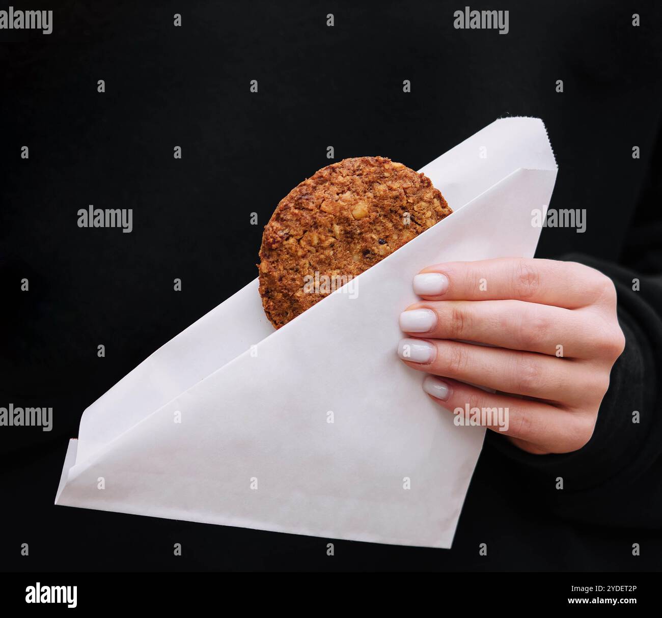 Donna che tiene in mano biscotti di farina d'avena in un bar Foto Stock