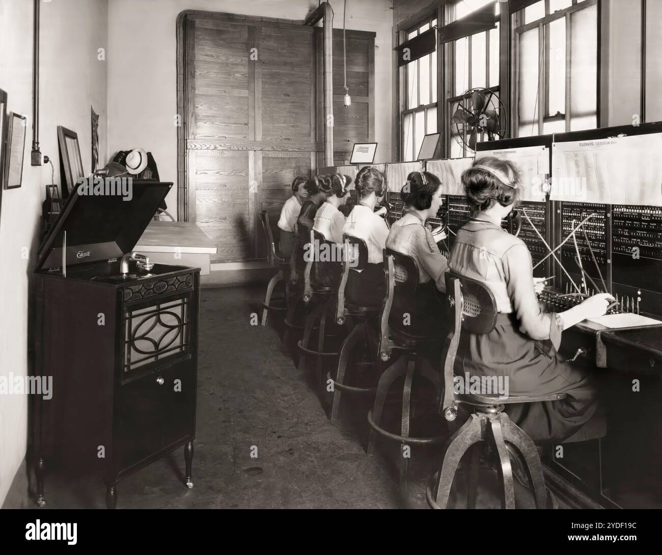 Operatori di centralino che ascoltano il fonografo di Edison, 1919, a montaggio digitale Foto Stock