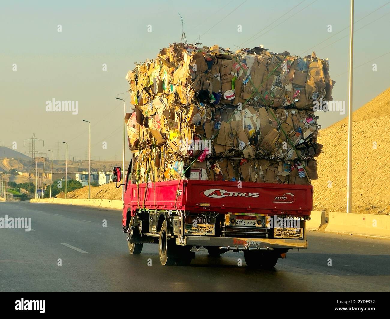 Giza, Egitto, 4 ottobre 2024: Un camion di trasporto pieno di rottami di carta di scarto di cartone marrone trasportati per il riciclaggio dopo essere stati raccolti, un camion ve Foto Stock