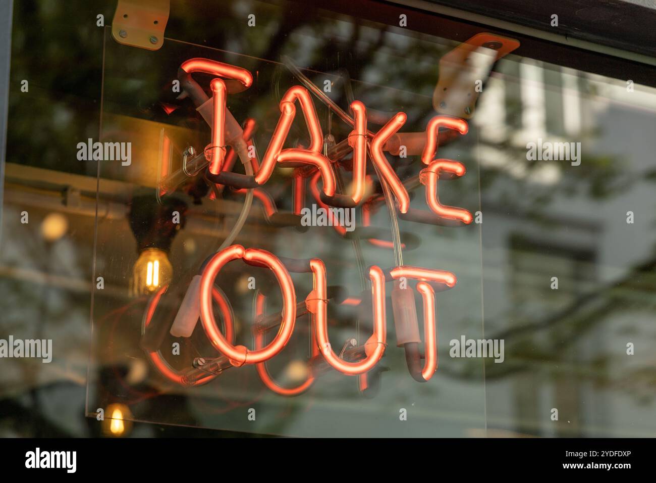 Cartello da asporto al neon dietro una finestra, il neon da asporto è per attirare l'attenzione dei clienti per portare a casa il cibo. Foto Stock