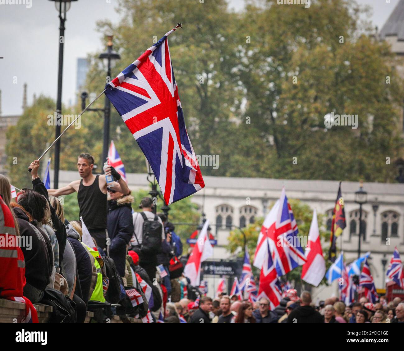 Londra, Regno Unito. 26 ottobre 2024. Folle di manifestanti sono alla fine di Whitehall, Piazza del Parlamento, per ascoltare gli oratori. La protesta "Uniting the Kingdom" organizzata per conto di Stephen Yaxley-Lennon (Tommy Robinson) vede migliaia di persone marciare dalla stazione Victoria a Whitehall e poi riunirsi a sostegno di Robinson. Crediti: Imageplotter/Alamy Live News Foto Stock