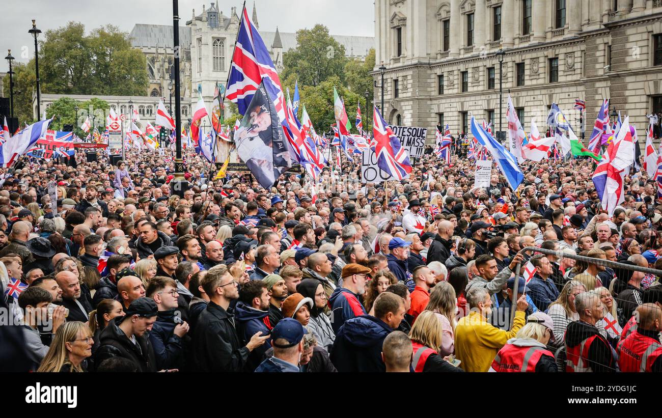 Londra, Regno Unito. 26 ottobre 2024. Folle di manifestanti sono alla fine di Whitehall, Piazza del Parlamento, per ascoltare gli oratori. La protesta "Uniting the Kingdom" organizzata per conto di Stephen Yaxley-Lennon (Tommy Robinson) vede migliaia di persone marciare dalla stazione Victoria a Whitehall e poi riunirsi a sostegno di Robinson. Crediti: Imageplotter/Alamy Live News Foto Stock