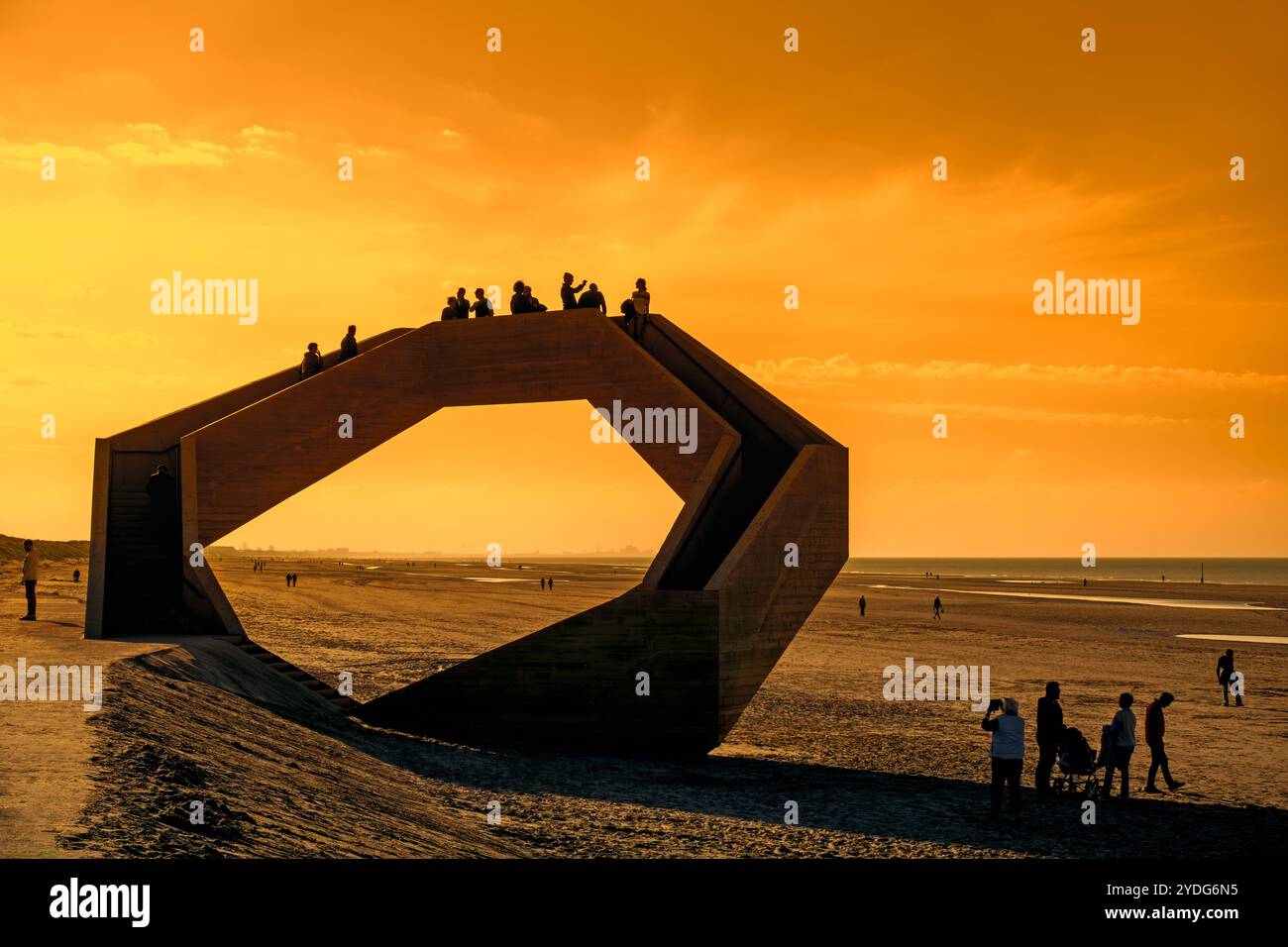 Westerpunt si staglia contro il cielo arancione del tramonto, scultura in cemento sulla spiaggia lungo la costa del Mare del Nord presso la località balneare De Panne, Fiandre occidentali, Belgio Foto Stock