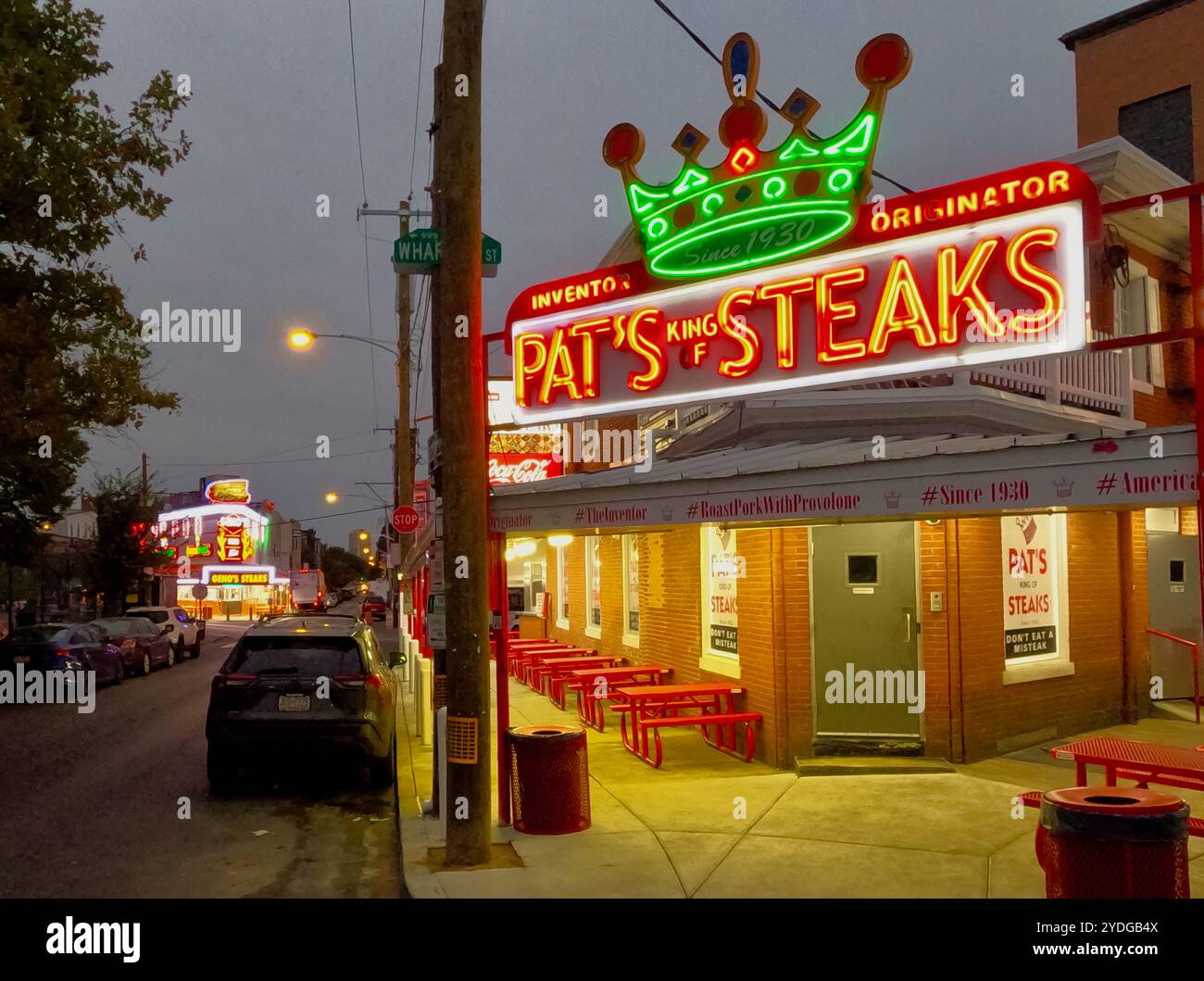 Il neon at Pat's Steaks e Geno's Steaks risplende poco prima dell'alba nel mercato italiano di Philadelphia. Foto Stock