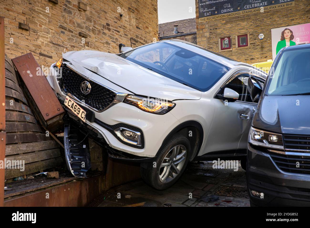 Regno Unito, Inghilterra, Yorkshire, Halifax, Centro città, Westgate, Electric MG Vehicle, veicolo elettrico fuori controllo, si è schiantato contro l'auto parcheggiata e la piantatrice di pavimentazioni Foto Stock