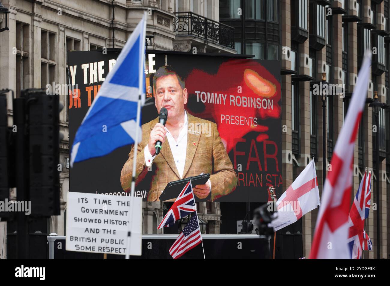 Londra, Regno Unito, 26 ottobre 2024. 1000 di folle di estrema destra che indossavano le bandiere di San Giorgio e gli Union Jacks marciarono verso Whitehall. L'organizzatore Tommy Robinson era assente dalla marcia Unite The Kingdom dopo essere stato rimesso in custodia venerdì. La protesta anti-governativa ha chiesto il rilascio di Robinson e ha insultato il nome di Keir Starmer. Credito : Monica Wells/Alamy Live News Foto Stock