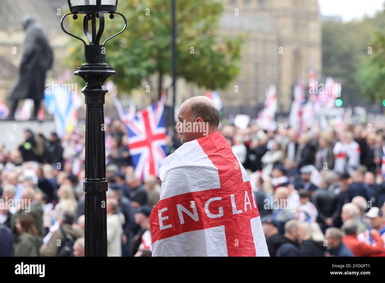 Londra, Regno Unito, 26 ottobre 2024. 1000 di folle di estrema destra che indossavano le bandiere di San Giorgio e gli Union Jacks marciarono verso Whitehall. L'organizzatore Tommy Robinson era assente dalla marcia Unite The Kingdom dopo essere stato rimesso in custodia venerdì. La protesta anti-governativa ha chiesto il rilascio di Robinson e ha insultato il nome di Keir Starmer. Credito : Monica Wells/Alamy Live News Foto Stock