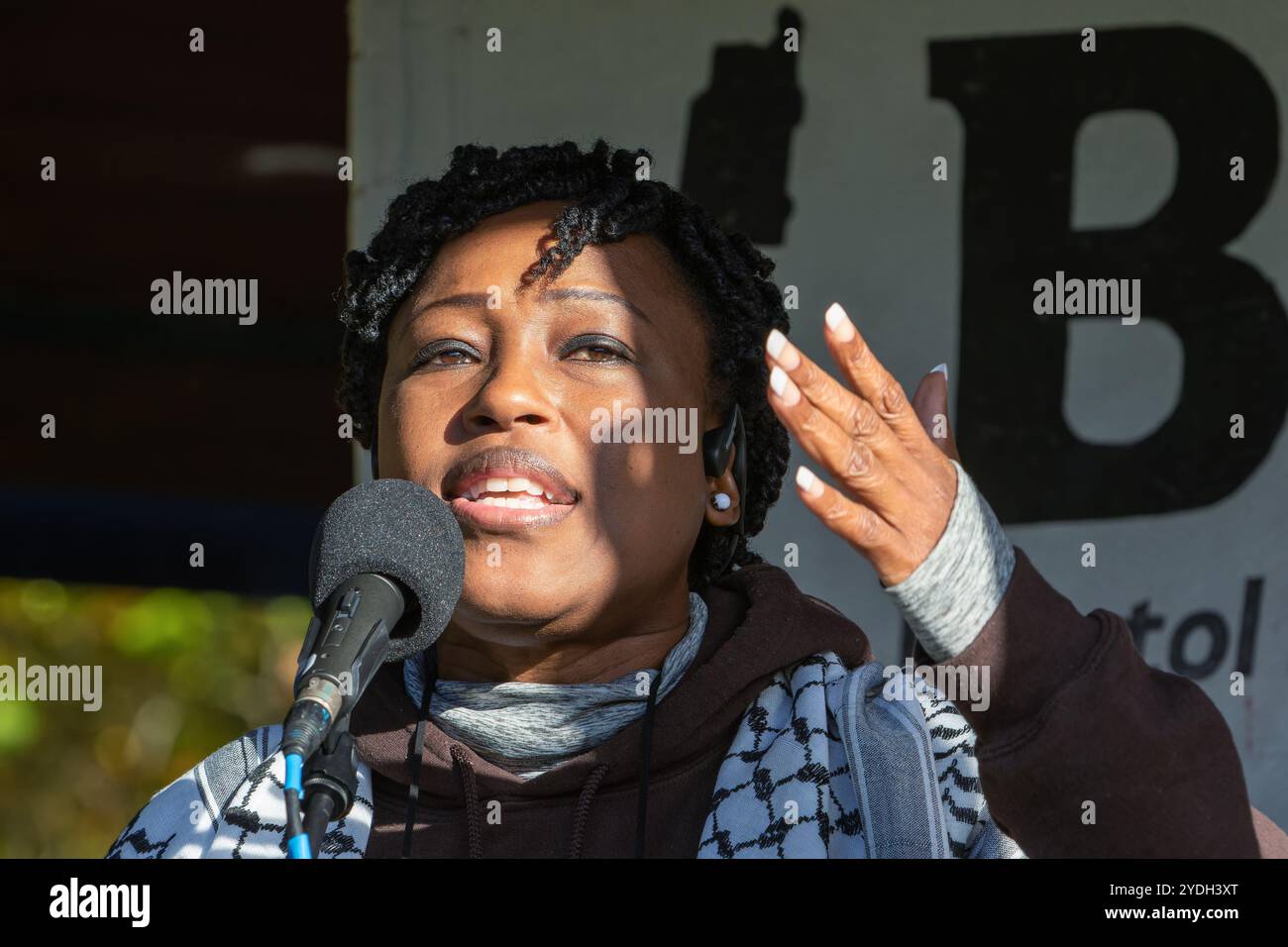 Bristol, Regno Unito. 26 ottobre 2024. Dopo una marcia di protesta pro palestinese sulla linea rossa per le strade di Bristol, l'autrice, attivista politica e per i diritti delle donne Shola Mos-Shogbamimu viene fotografata a Castle Park mentre parla con i manifestanti. I sostenitori della Palestina hanno marciato intorno a Broadmead portando una striscia di tessuto rosso lunga chilometri per evidenziare tutte le linee rosse attraversate dal governo israeliano dopo un anno di combattimenti a Gaza. Crediti: Lynchpics/Alamy Live News Foto Stock