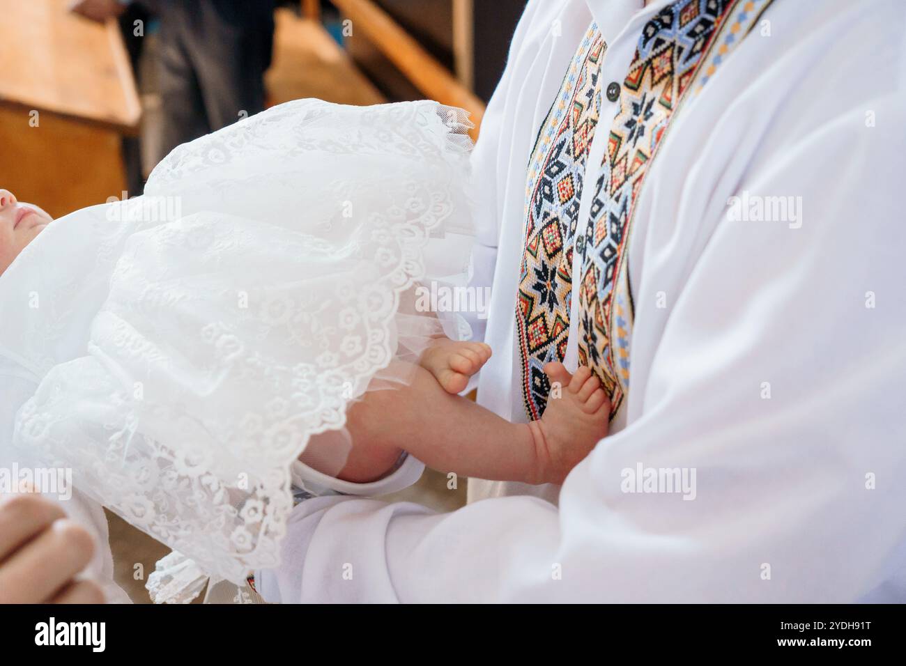 Un momento tenero durante una cerimonia di battesimo. Foto Stock