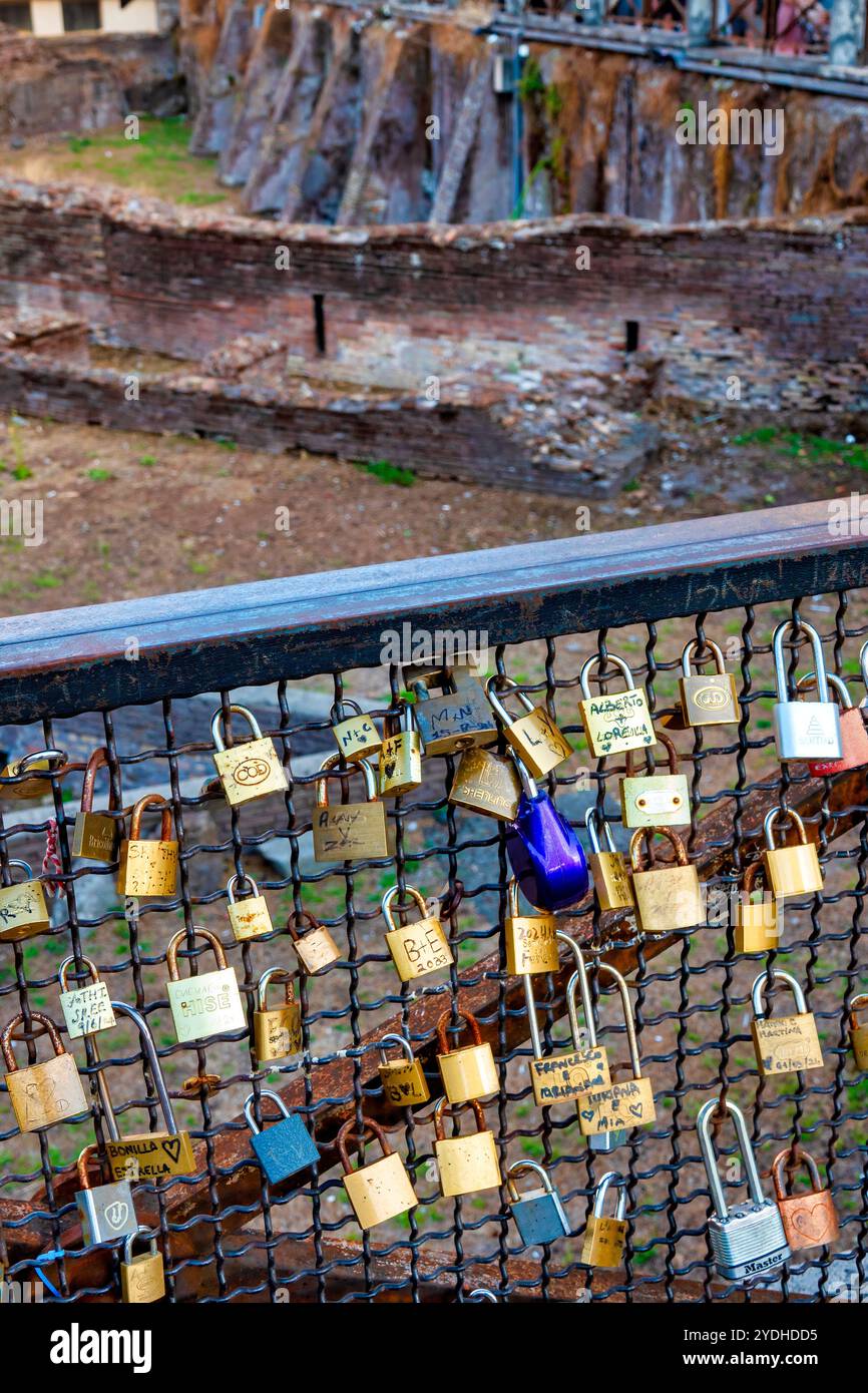 Lucchetti d'amore attaccati a una recinzione che domina le antiche rovine del Ludus Magnus, Roma, Italia. Foto Stock