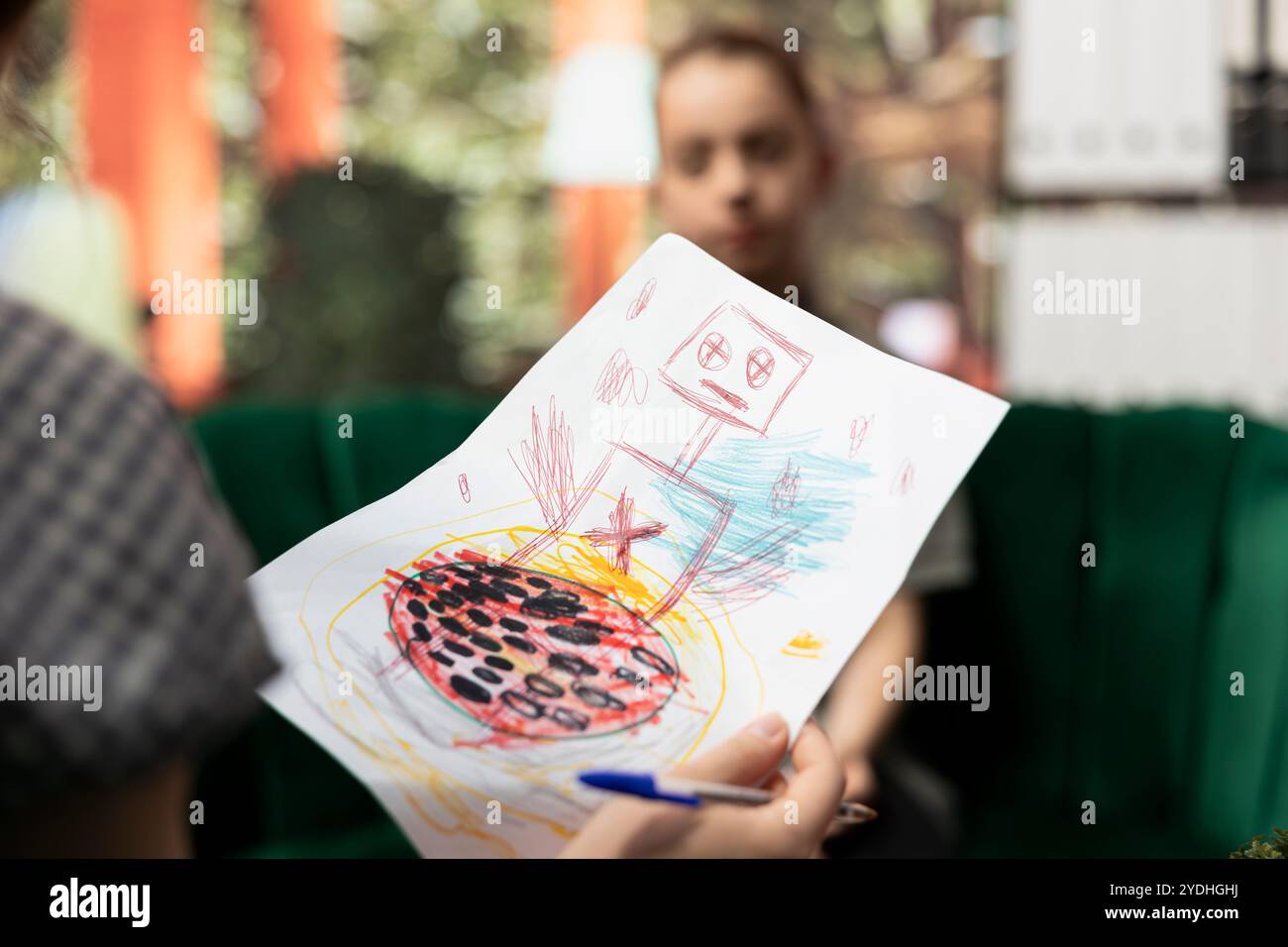 Il terapeuta studia disegni spaventosi da un adolescente in difficoltà, facendo una psicoanalisi durante una sessione di terapia. Gli schizzi scuri raffigurano un comportamento violento inquietante, inquietanti segnali di pericolo. Primo piano. Foto Stock