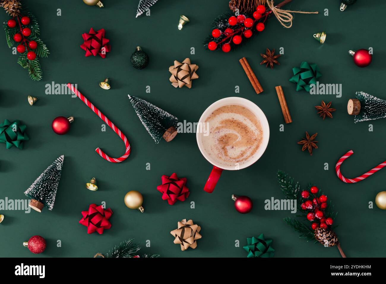 Modello natalizio realizzato con oggetti invernali e natalizi con bevanda calda su sfondo verde. Concetto creativo minimalista di Natale e Capodanno. Foto Stock