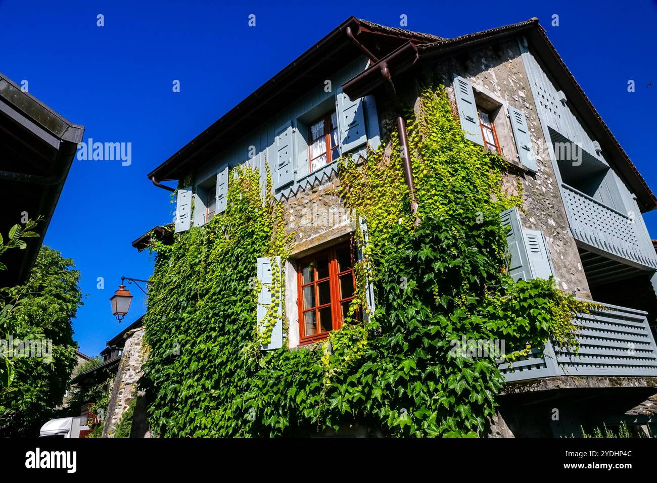 Case in pietra medievali ricoperte di edera lungo la riva francese del lago di Ginevra nel piccolo villaggio di Nernier, alta Savoia, Francia. Foto Stock