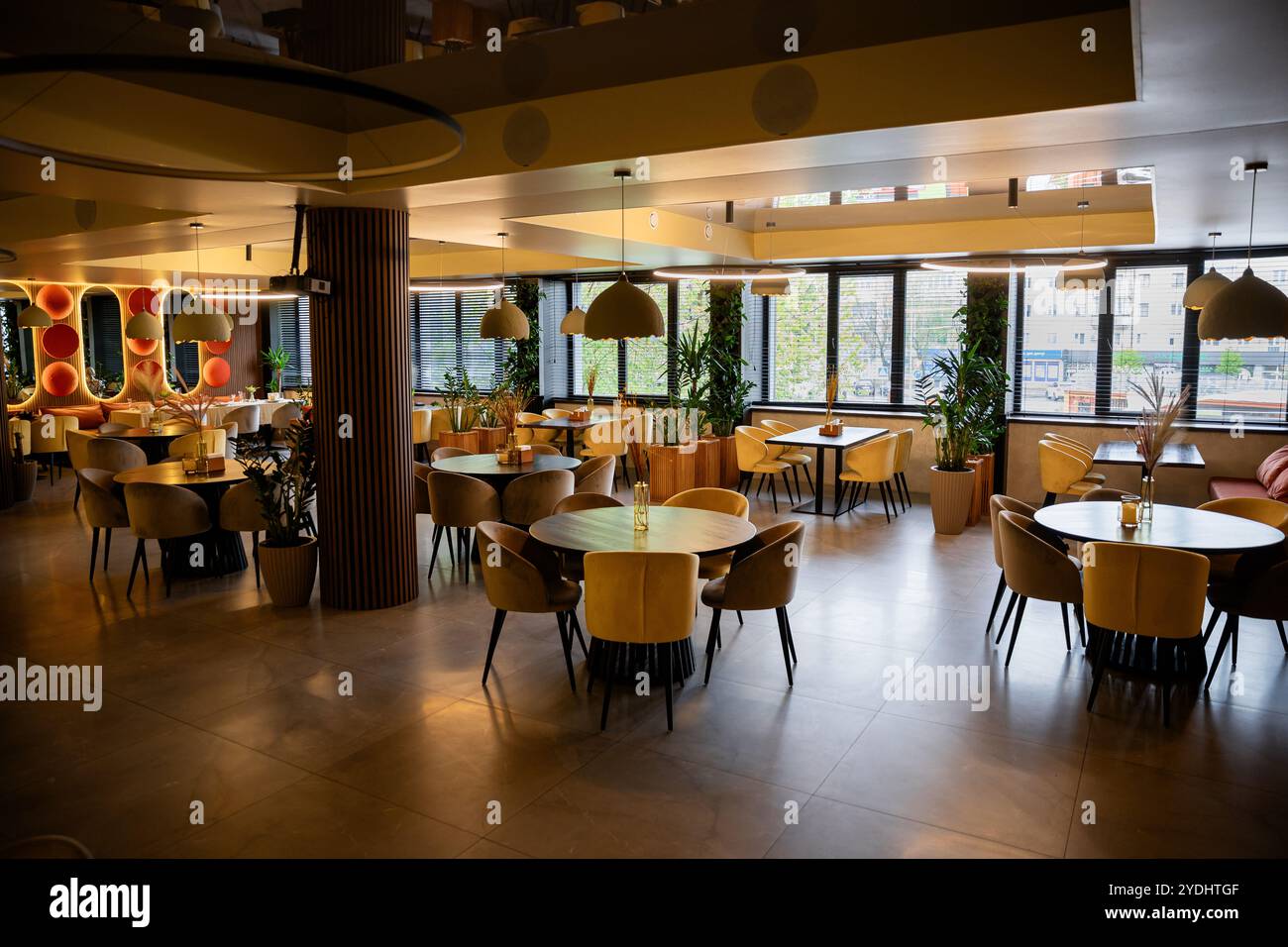 Eleganti interni del ristorante con luce naturale, arredi accoglienti e tavoli eleganti Foto Stock