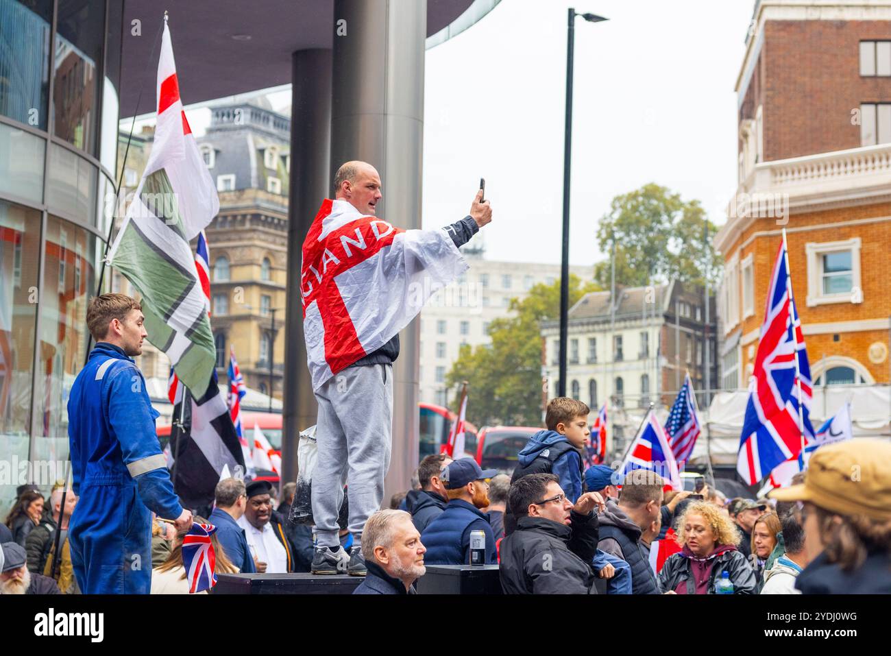 Londra, Regno Unito. 26 OTTOBRE 2024. La bandiera dell'uomo in Inghilterra si erge su una scatola elettrica mentre migliaia di persone si sono riunite per la manifestazione Unite the Kingdom organizzata da Tommy Robinson, che non era presente a causa della detenzione in carcere, riunendosi a Victoria la marcia si è pacificamente fatta strada verso la piazza del Parlamento, dove è stato proiettato un nuovo documentario "Lawfare". Resistere al razzismo ha mobilitato una contro protesta anche con migliaia di persone, che si sono riunite pacificamente all'altra estremità di whitehall. Credito Milo Chandler/Alamy Live News Foto Stock