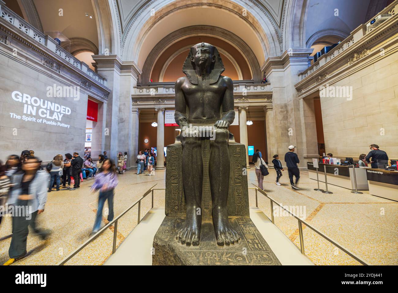 Antica statua egizia del faraone in mostra nella grande sala del Metropolitan Museum of Art circondato da visitatori e archi. New York. STATI UNITI. Foto Stock