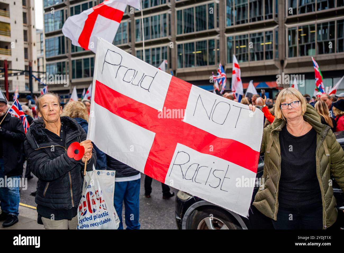 Londra, Regno Unito. 26 ottobre 2024. I manifestanti tengono una bandiera durante la dimostrazione. L'estrema destra discendeva nel centro di Londra nonostante il loro leader Tommy Robinson fosse assente a causa di essere stato rimandato dalla polizia. Infuriata dal recente suicidio di Peter Lynch mentre era in custodia per disordini violenti, la manifestazione si riunì fuori Downing Street sotto la bandiera di "Uniting the Kingdom". (Foto di Lab Ky Mo/SOPA Images/Sipa USA) credito: SIPA USA/Alamy Live News Foto Stock