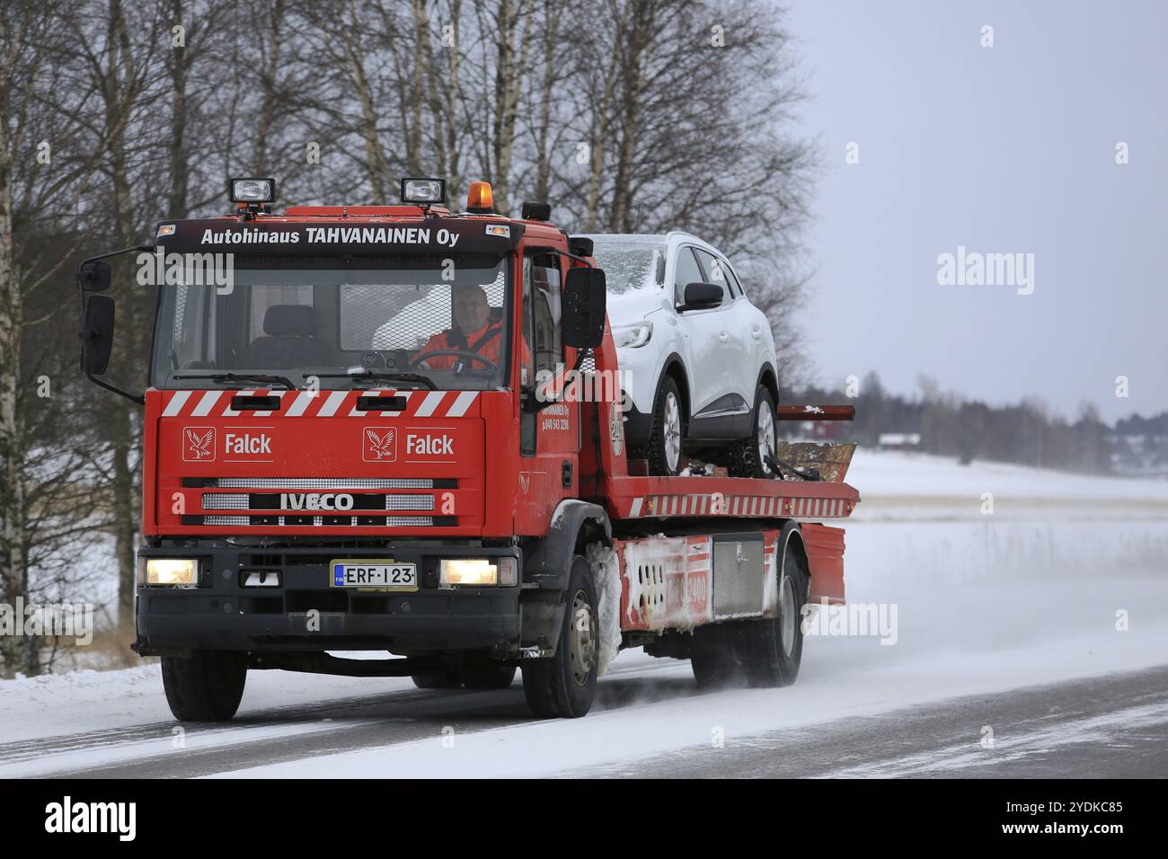 SALO, FINLANDIA, 7 GENNAIO 2017: Il carro trainato rosso Iveco traina un'auto lungo la strada in una giornata fredda in inverno. Le temperature al di sotto dello zero possono causare molti problemi meccanici Foto Stock