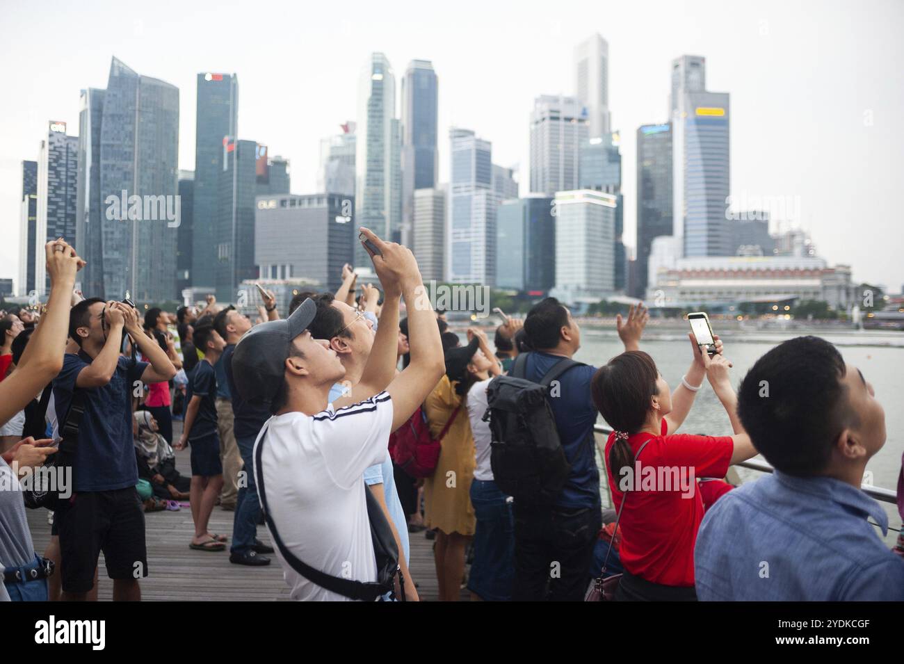 04.08.2018, Singapore, Repubblica di Singapore, Asia, i visitatori guardano una manovra di volo dell'aeronautica locale sopra Marina Bay contro l'imponente schiena Foto Stock