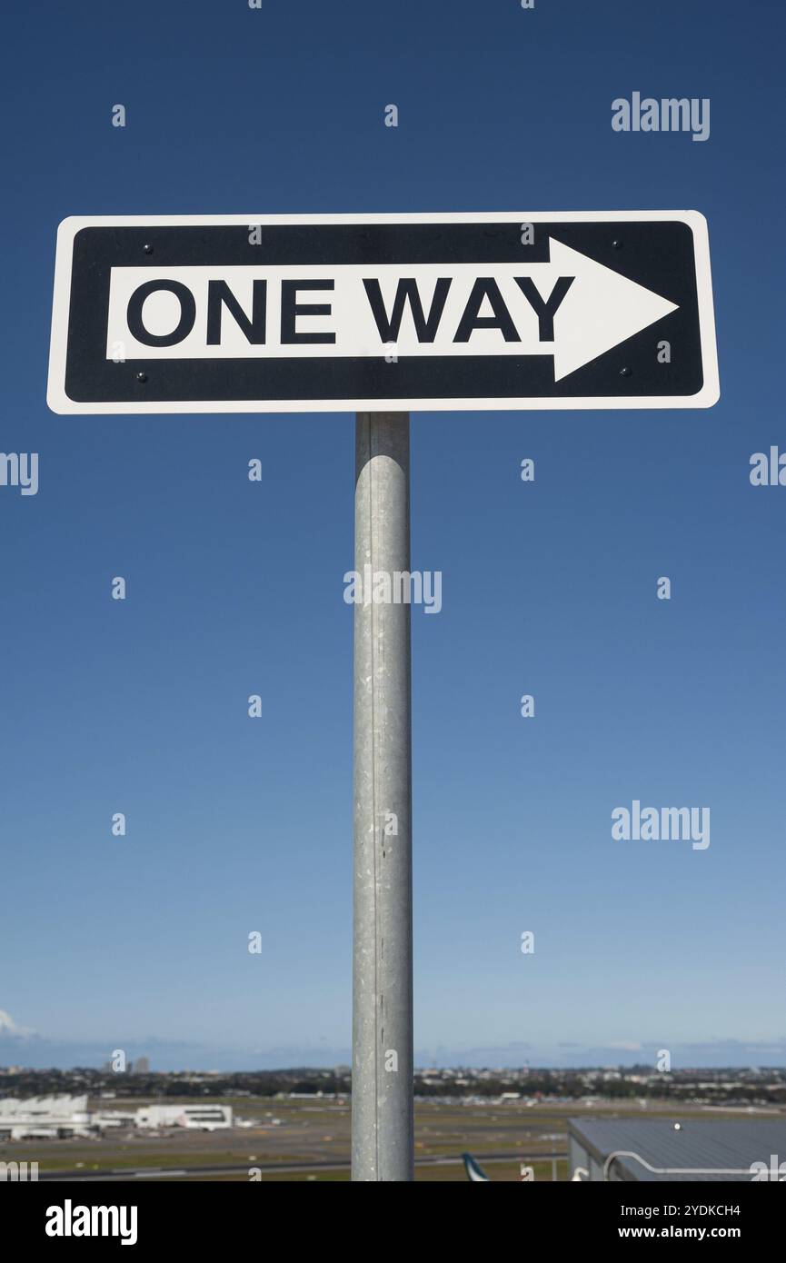 28.09.2019, Sydney, New South Wales, Australia, cartello stradale a senso unico con freccia direzionale contro un cielo blu su un ponte di parcheggio dell'aeroporto, Oceania Foto Stock