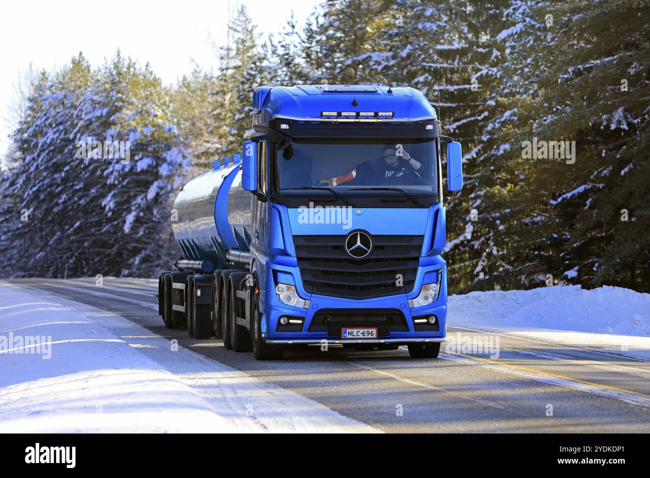 Camion cisterna blu Mercedes-Benz Actros Haenninen Group Oy per il trasporto di merci sfuse sull'autostrada 52 in una giornata di sole d'inverno. Salo, Finlandia. 11 febbraio 2021 Foto Stock