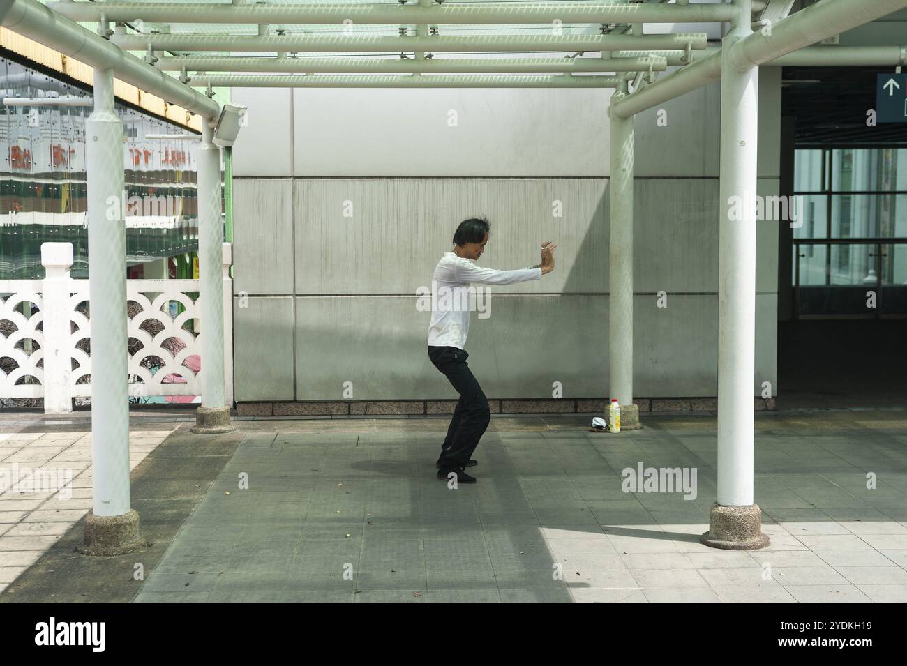 18.04.2018, Singapore, Repubblica di Singapore, Asia, Un uomo esegue esercizi di tai chi in un piccolo parco fuori dal complesso del Parco del popolo di Singapore Foto Stock