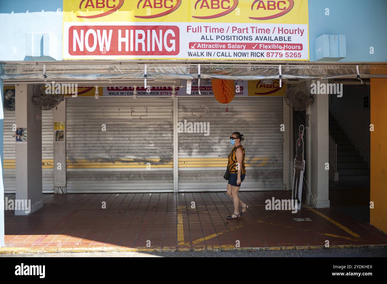 22.04.2020, Singapore, Repubblica di Singapore, Asia, Una donna cammina davanti a negozi chiusi in una zona pedonale nel distretto di Ang Mo Kio. Sta indossando un Foto Stock
