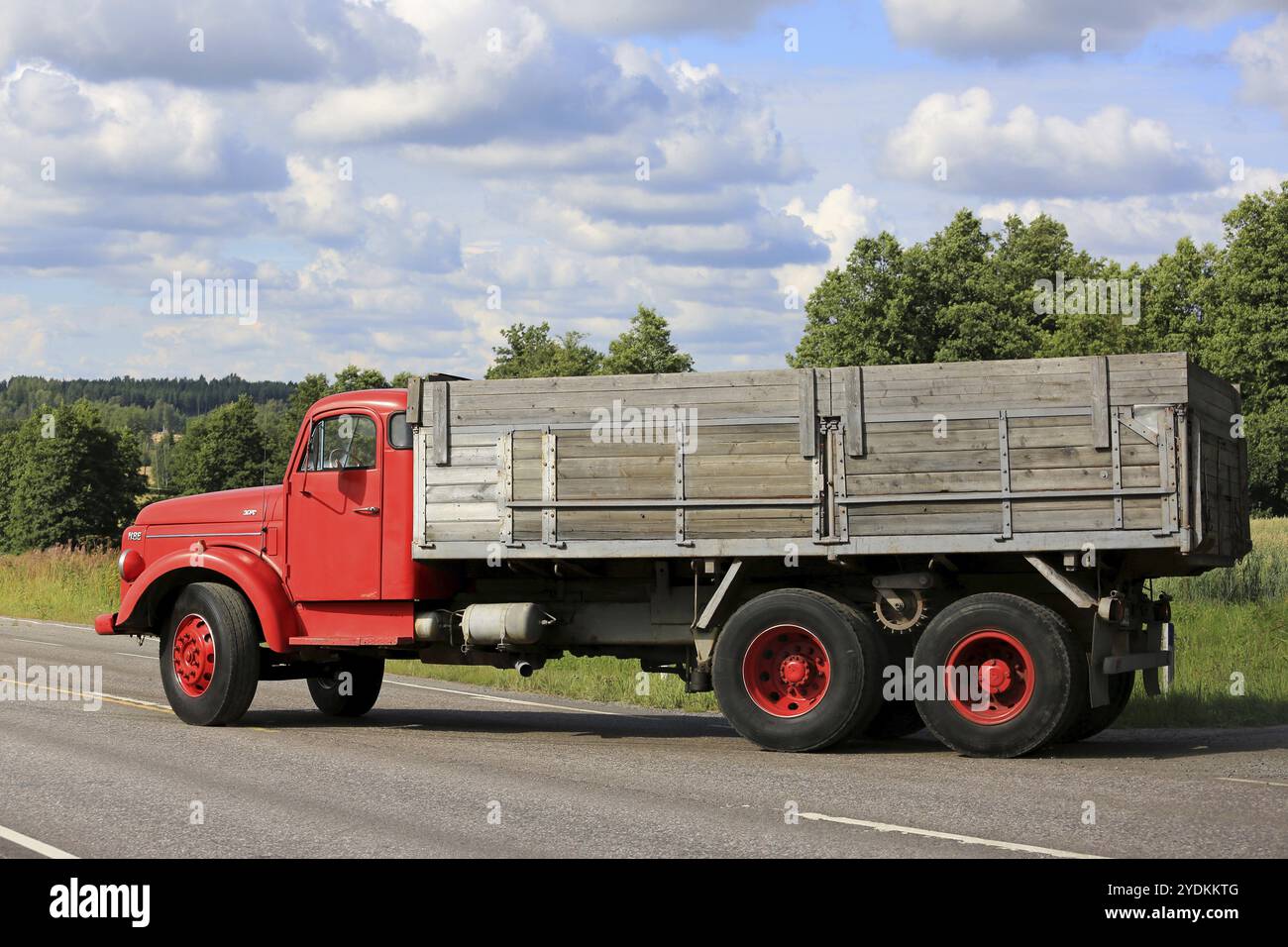 TENHOLA, FINLANDIA, 30 LUGLIO 2016: Vista laterale del camion Volvo N86 rosso convenzionale che gira a destra per entrare nella strada principale in una bella giornata d'estate Foto Stock