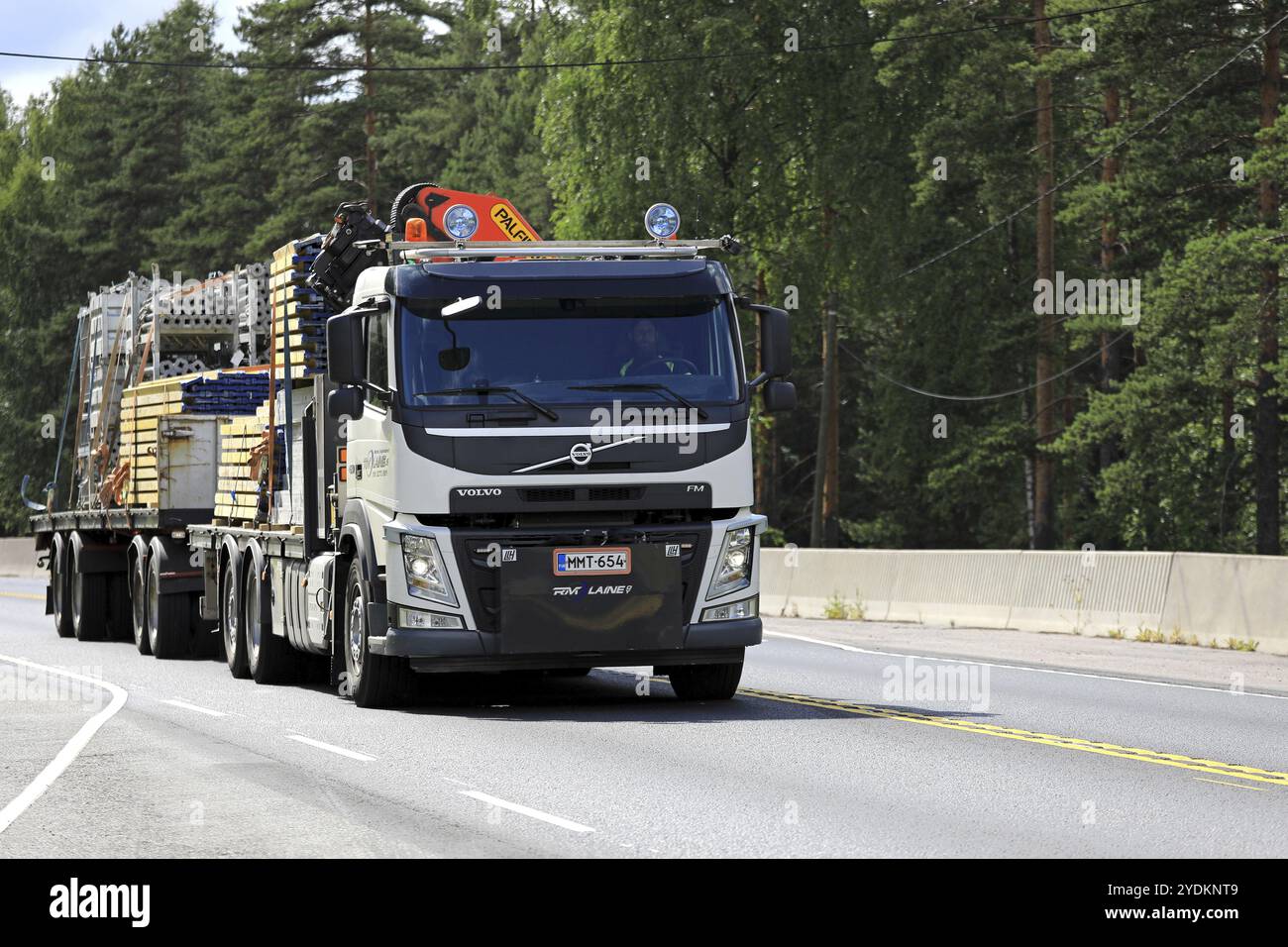 NUMMELA, FINLANDIA, 21 LUGLIO 2017: Volvo FM bianca con gru RM Laine Oy trasporta materiali da costruzione su rimorchio lungo l'autostrada Foto Stock