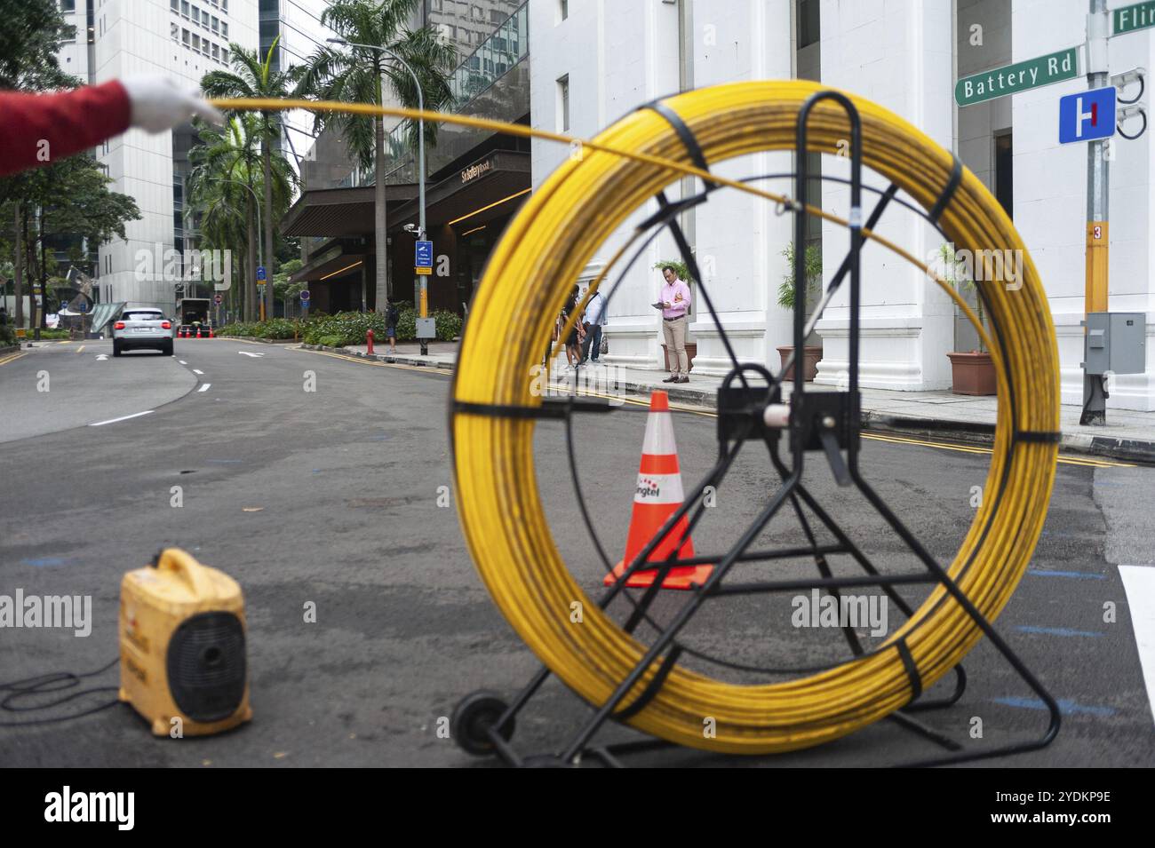 15.04.2018, Singapore, Repubblica di Singapore, Asia, Un lavoratore posa cavi su una strada nel quartiere degli affari, Asia Foto Stock